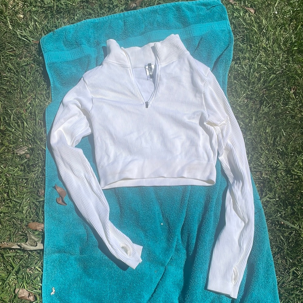 White long sleeve with zipper and thumb placers . Never been worn